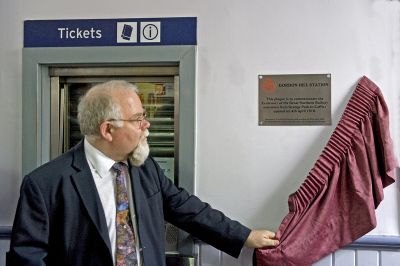 Rufus Barnes unveiling centenary plaque at Gordon Hill station
To mark the 100th anniversary of the extension of the GN route from Enfield Chase to Cuffley, First Capital Connect named a Class 313 train in honour of Captain William Leefe Robinson in recognition of his part of the area’s history, when he shot down a German airship over Cuffley during the First World War in 1916.

As part of the celebrations, Rufus Barnes, former Chief Executive of London Travel Watch,  unveiled a commemorative plaque donated by The Enfield Society at Gordon Hill ticket hall.

Neal Lawson, Managing Director of FCC said: "It was great to see so many people attend the event and recognise a fine history on this part of the railway. This emphasises how important our railway has been and will continue to be to the local community. We are committed to deliver the next chapters of this railway's history with extra services from December and for the longer term through the Thameslink Programme."
Keywords: plaques;GNR centenary;railway stations