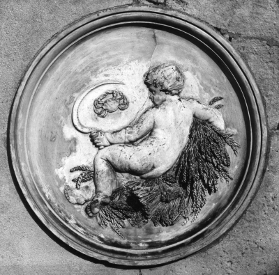 Plaque in the orangery, Trent Park
Probably representing the zodiac sign "Cancer", from the image of a crab, though the putto is holding a reaping hook and a sheaf of wheat, which looks like "autumn", whereas Cancer's dates are 21st June – 22nd July - perhaps rather early for autumn. There is a similar plaque of "Aries" with a putto holding a basket of flowers.
Keywords: sculpture;plaques