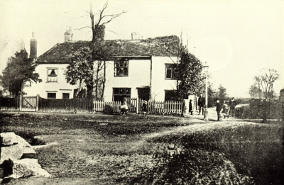 Sir Walter Raleigh's old house at Chase Side
Gordon Road is by the lamp post. Pinnock's Pond is to the left of the stones on the left of the picture. Pinnock was at one time owner of the Six Bells pub and at one time had only a six day licence. This house was demolished in 1886. 

[i]Reproduction right held by Enfield Local Studies Library and Archive.[/i]
Keywords: demolished buildings;ponds