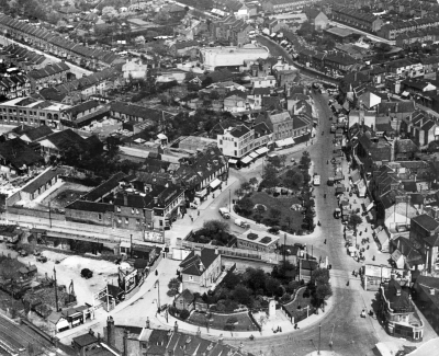 Edmonton Green in 1969
Aerial view, shortly before the area arond the green was razed to the ground to make way for the Edmonton Green shopping centre and tower blocks. Hertford Road curves away in the background; in the foreground the low level railway (built in 1849) cuts through the ancient green. The war memorial, centre foreground, was the only feature incorporated into the new development. The EPS commented adversely on some of the changes. - [i]Fighting for the future[/i], page 274.
Keywords: 1960s;aerial;railway stations;rail transport;LC2;EP1