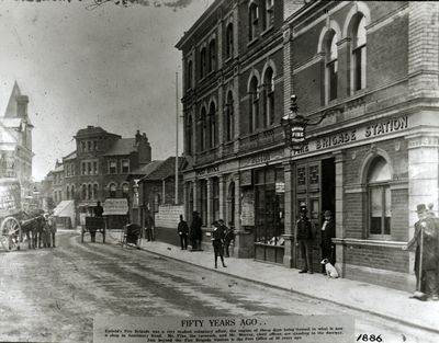 Old fire station, Southbury Road, 1886
Caption in picture reads "Fifty years ago ... Enfield's Fire Brigade was a very modest voluntary affair, the engine of those days being housed in what is now a shop in Southbury Road. Mr. Pike, the turncock, and Mr. Murray, chief officer, are standing in the doorway. Just beyond the Fire Brigade Station is the Post Office of 50 years ago. 1886"
Keywords: 1880s;fire stations;firemen;post offices;horse-drawn vehicles;roads and streets